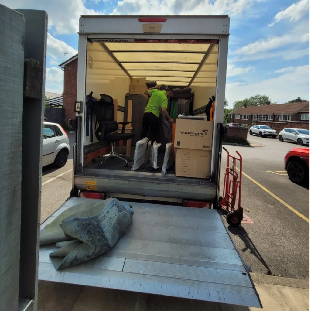 The Mepro Removals team executing professional Pre-Renovation Removals Manchester, carefully wrapping a large armchair in protective material.